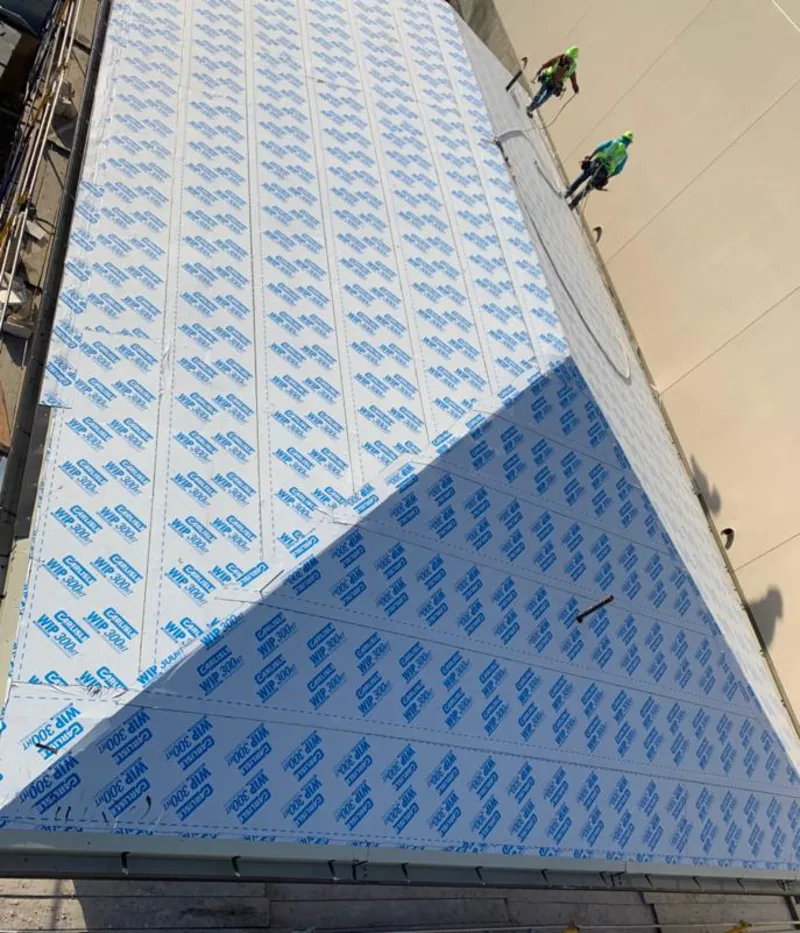 Professional roofers installing underlayment on a metal roof in New Freedom